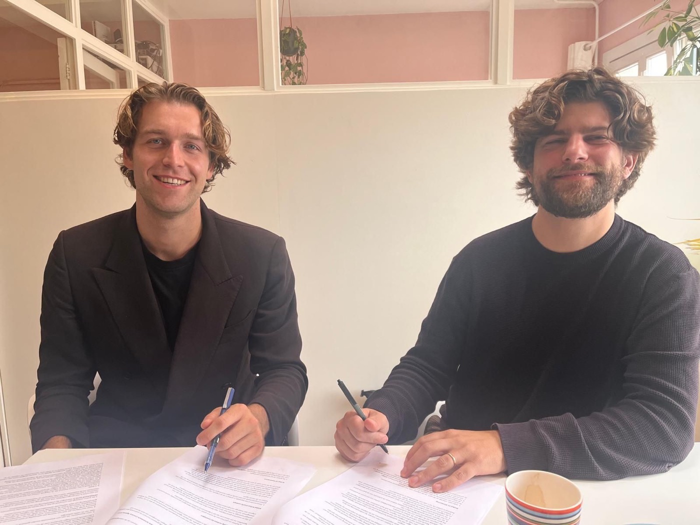 Thomas Huttinga tekent het boekcontract bij uitgeverij Ten Have, naast zijn redacteur