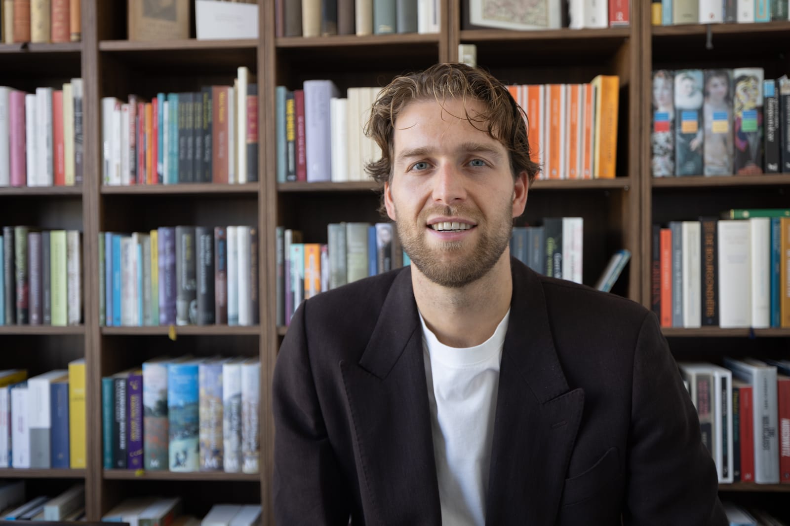 Thomas Huttinga voor zijn boekenkast