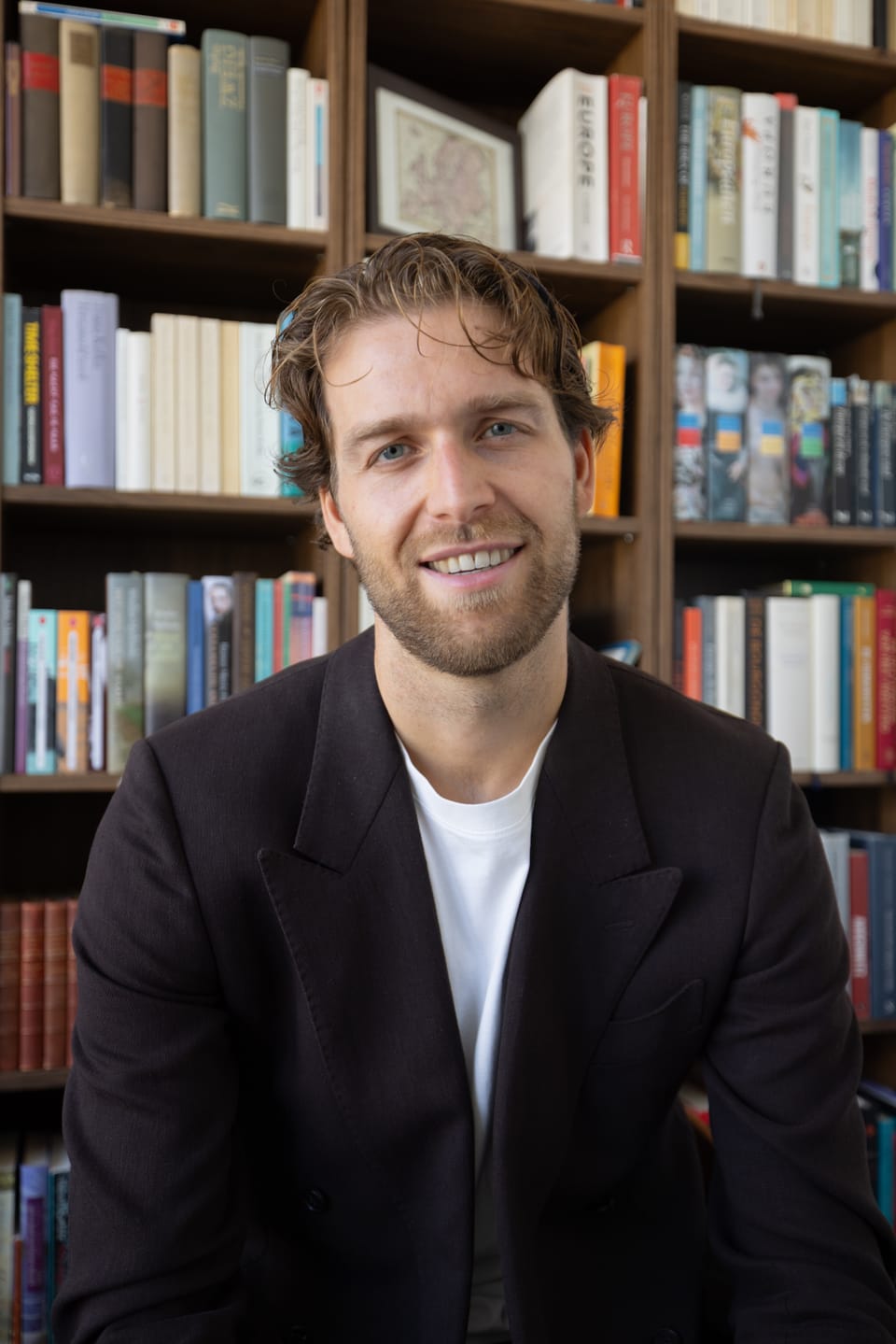 Thomas Huttinga voor zijn boekenkast